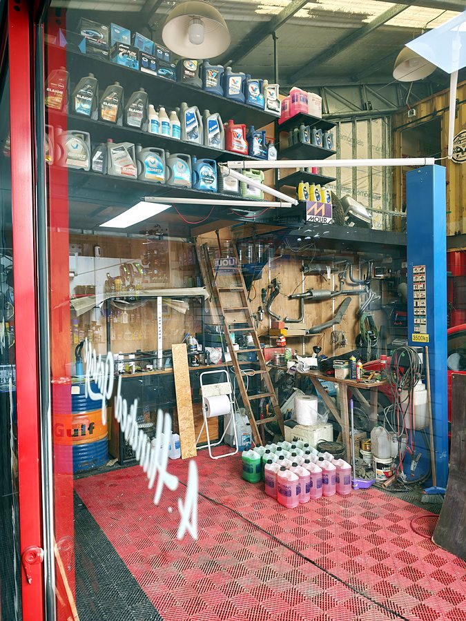 Box del taller con piso rojo y estanterías de productos